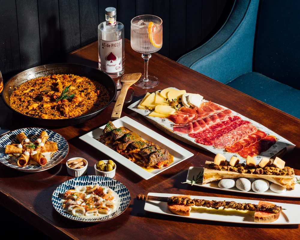 Mesa con tapas, paella y jamón